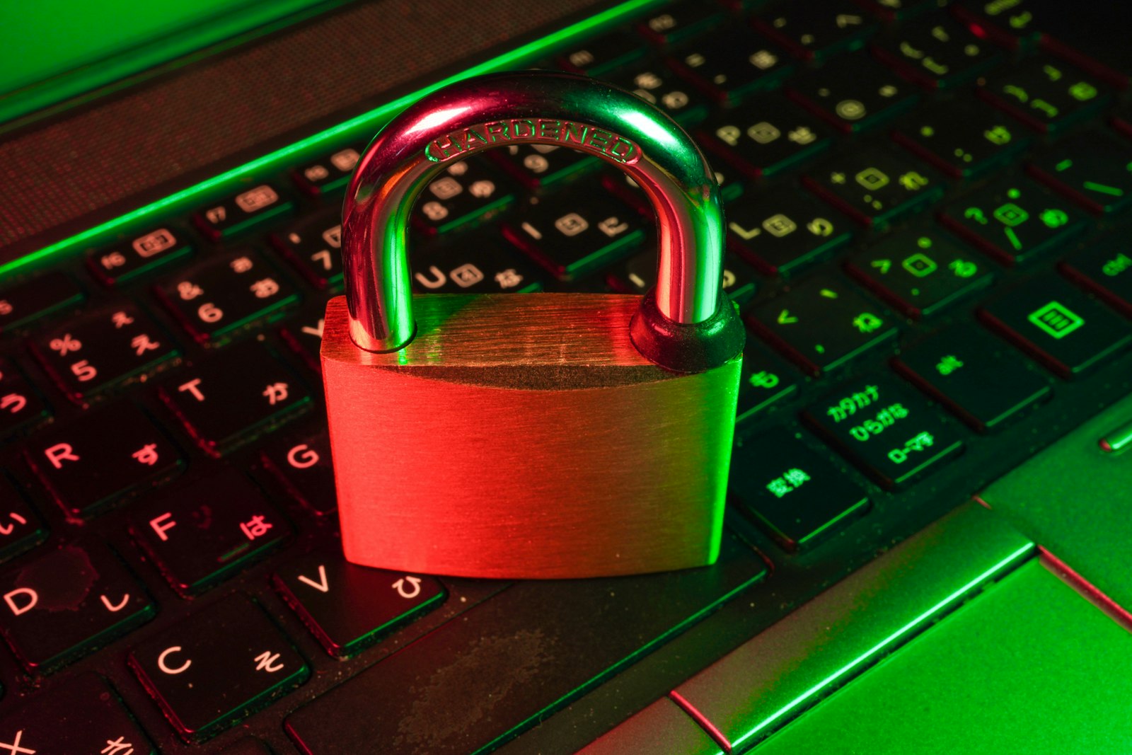 Red padlock resting on a black computer keyboard, representing email and cybersecurity protection
